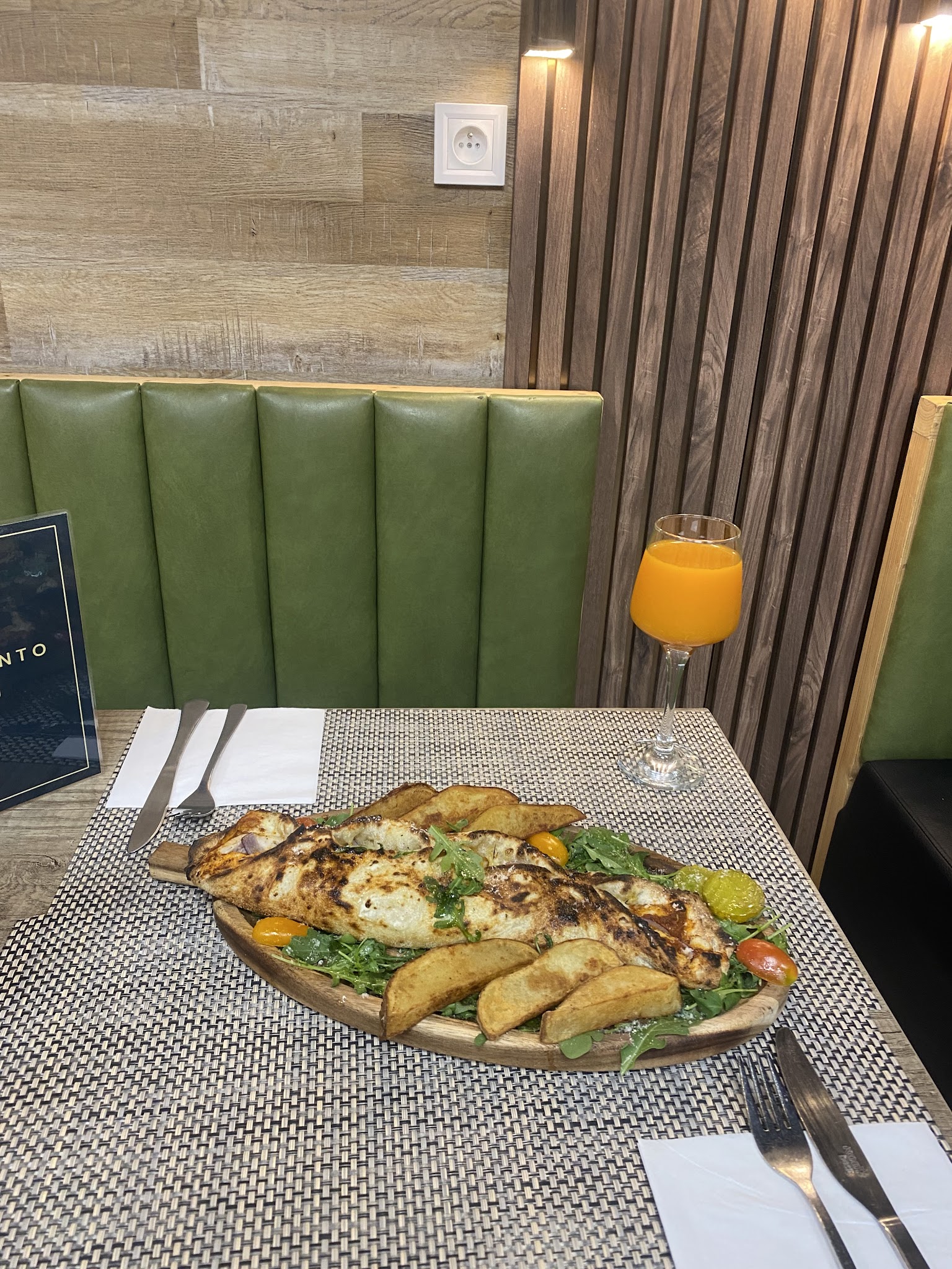 Plat servi en salle sur la banquette verte de la pizzeria